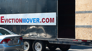 Truck with open loading door, sign says "Eviction Mover"