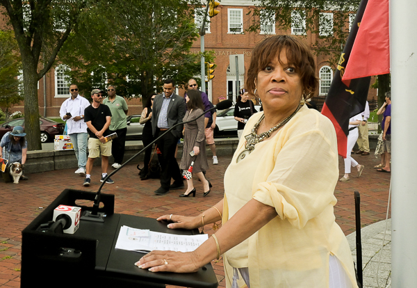 Doreen Wade stands at lectern in Riley Square, Salem