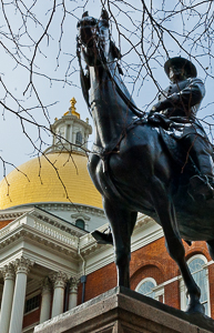 Statue of man on horse with golden dome of the state house in background