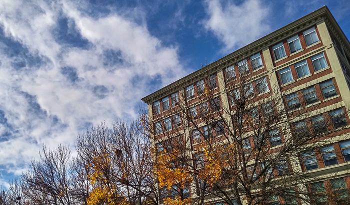 Apartment building, fall foliage, clouds