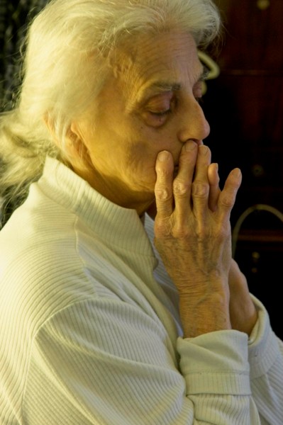 UNHAPPY WOMAN CLASPS HANDS