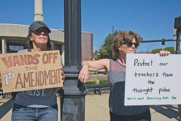 two women holding signs