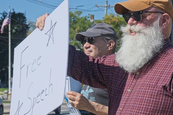 bearded man holds sign